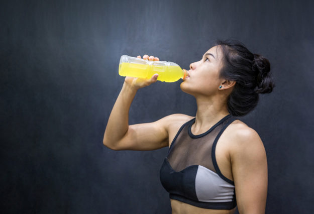 Young Asian athlete woman drinking sport drink or energy drink after exercise